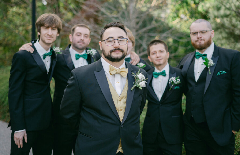 Documentary style wedding photo of a groom with groomsmen